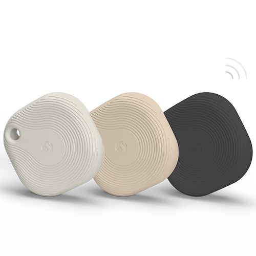 Three square Bluetooth tracking devices in white, beige, and black, each with rounded edges and a circular pattern, are displayed standing upright against a plain white background.