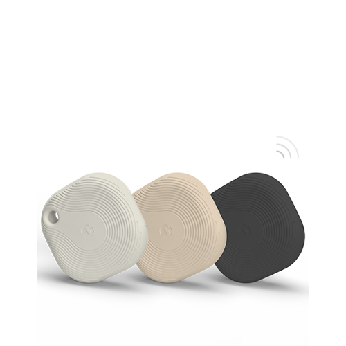 Three square-shaped Bluetooth tracking devices in white, beige, and black, each with a textured circular pattern, are displayed standing upright against a plain white background.