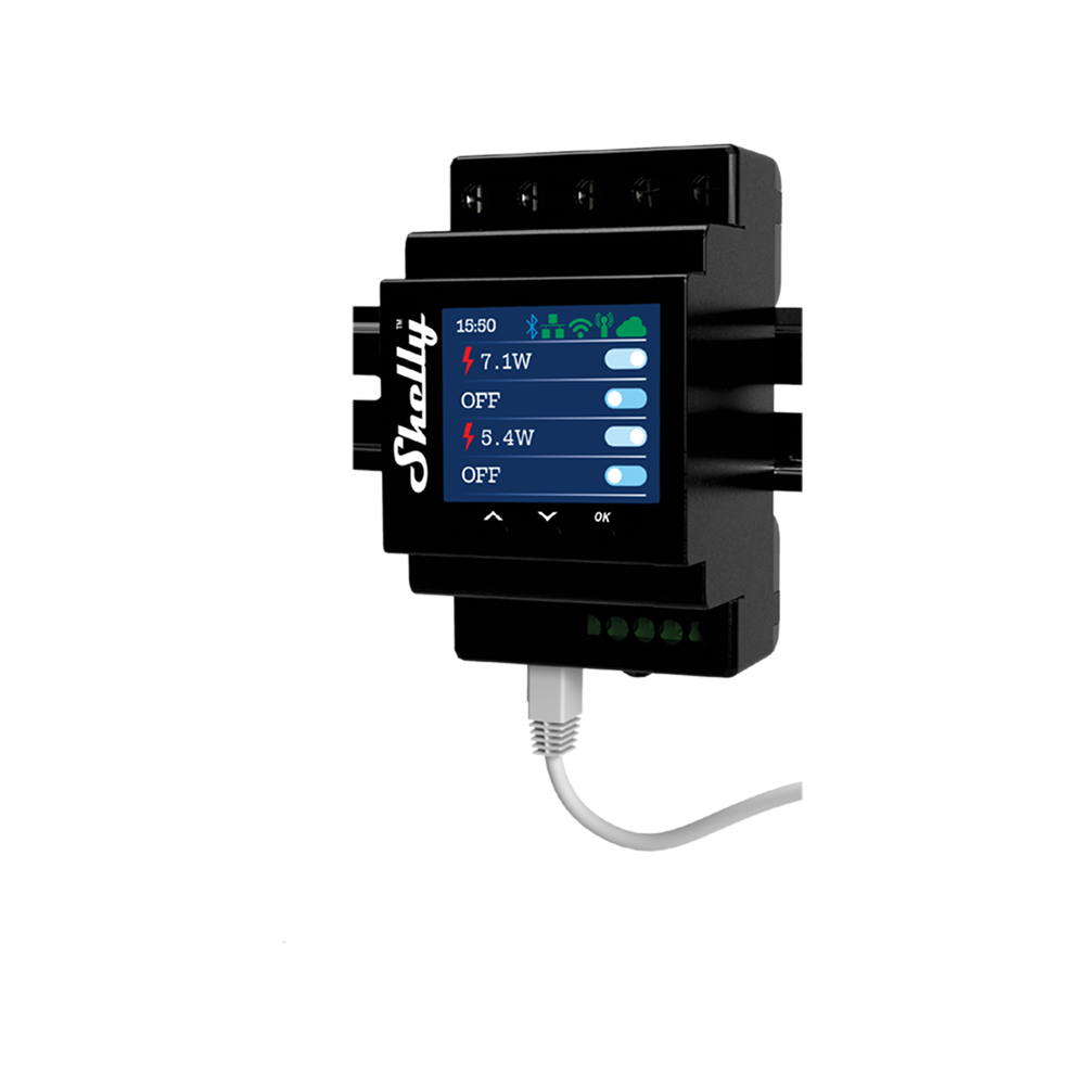 A black Shelly smart relay device is mounted on a wall, featuring a small screen displaying power usage readings and status indicators. A white cable is plugged into the bottom of the device.
