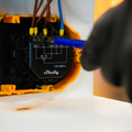 A person using the Shelly USA Shelly Shutter + BLU Button Tough1 Pack to connect wires.