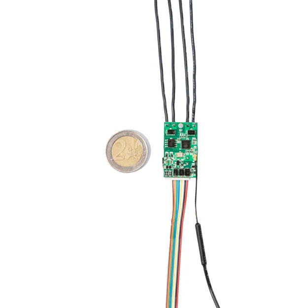 The Shelly USA Shelly Uni, a compact smart Wi-Fi module with multicolored wires, is displayed beside a 2 euro coin for size comparison on a white background.